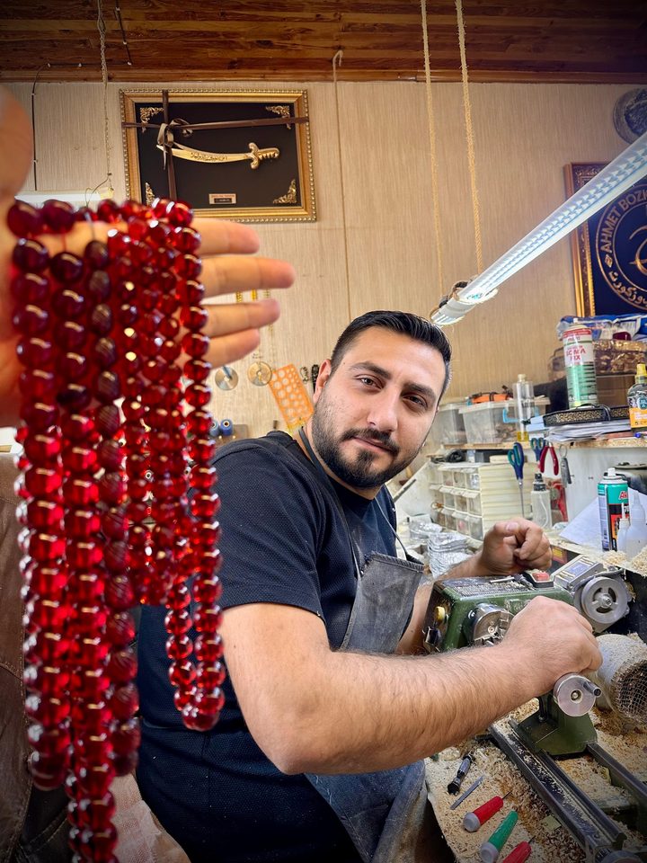 Nakkaş Ahmet Bozkurt Savanç, Konya’daki atölyesinde tezgâh başında, kırmızı tesbihle